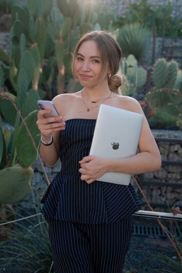 Judith con el móvil y el portátil entre cactus